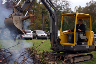 Mike uses heavy equipment to add more wood to the spectacular bonfire.